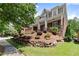Charming home featuring a stone retaining wall, manicured lawn, and a inviting front porch at 1286 Whisper Cove Dr, Buford, GA 30518