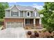 Beautiful two-story home with a brick and gray facade, two-car garage, and a welcoming front porch at 1286 Whisper Cove Dr, Buford, GA 30518