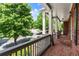 Inviting front porch featuring brick flooring, stone accents, and classic railing overlooking the serene street at 1286 Whisper Cove Dr, Buford, GA 30518