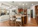 Kitchen island with granite countertop and seating, connecting to the adjacent living and dining areas at 1286 Whisper Cove Dr, Buford, GA 30518