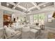 Open-concept living room with coffered ceiling flowing into the kitchen and dining areas at 1286 Whisper Cove Dr, Buford, GA 30518