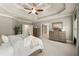 Well-lit main bedroom with tray ceilings, an ensuite bathroom, and neutral tones at 1286 Whisper Cove Dr, Buford, GA 30518