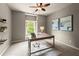 Well-lit office space features a modern desk, neutral walls, floating shelves and ample natural light from the window at 1286 Whisper Cove Dr, Buford, GA 30518