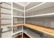 Walk-in pantry features custom wood shelving and metal retaining rods at 1286 Whisper Cove Dr, Buford, GA 30518