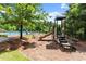 View of a community playground with slide and picnic tables with the community pool partially visible in the background at 1286 Whisper Cove Dr, Buford, GA 30518