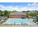 Community pool with tables, umbrellas, lounge chairs, a splash pad, and slides with the back of the clubhouse behind it at 1286 Whisper Cove Dr, Buford, GA 30518