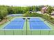 Aerial view of community tennis courts with an overhead view of the community pool and clubhouse in the background at 1286 Whisper Cove Dr, Buford, GA 30518