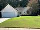 Close-up of charming single story home featuring an attached two car garage and well maintained lawn at 159 Parkside Dr, Stockbridge, GA 30281