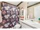 Cozy bathroom featuring a floral shower curtain, cabinet, and neutral-toned decor at 179 Parkside Dr, Stockbridge, GA 30281
