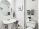 Stylish half bathroom showcasing a pedestal sink, toilet with classic fixtures, and elegant decorative touches at 179 Parkside Dr, Stockbridge, GA 30281