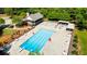 Aerial view of a community swimming pool with lounge chairs, tables with umbrellas, and clubhouse at 3627 Pebble Hill Ne Dr, Marietta, GA 30062