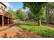 Lush backyard featuring a wooden deck with stairs and a meticulously maintained lawn enclosed by a rustic wooden fence at 470 W Magnolia Cir, Johns Creek, GA 30005