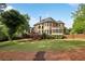 Expansive backyard with a multi-tiered deck, mature trees, and meticulously manicured landscaping at 470 W Magnolia Cir, Johns Creek, GA 30005