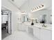 Bright bathroom featuring dual sinks, white cabinetry, large mirror, and open doorway to the bedroom at 470 W Magnolia Cir, Johns Creek, GA 30005
