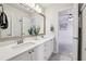 Bright bathroom featuring dual sinks, white countertops, and a large mirror with a view to bedroom at 470 W Magnolia Cir, Johns Creek, GA 30005