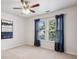 Bedroom featuring large windows with backyard views, light walls, carpet, ceiling fan, and blue drapes at 470 W Magnolia Cir, Johns Creek, GA 30005