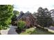Stately brick home with lush landscaping, manicured lawn, mature trees, and a circular driveway for curb appeal at 470 W Magnolia Cir, Johns Creek, GA 30005