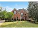 Stately brick home with manicured lawn and mature trees, showcasing classic architectural details and inviting curb appeal at 470 W Magnolia Cir, Johns Creek, GA 30005