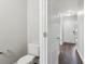 Half-bathroom featuring white toilet and a view of the front door and main hall at 7712 Autry Circle # 204, Douglasville, GA 30134