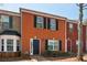 Brick townhouse with black shutters and door, showcasing a classic and inviting facade on a sunny day at 7712 Autry Circle # 204, Douglasville, GA 30134