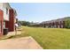 View of backyard and exterior featuring red brick and white siding townhomes at 7712 Autry Circle # 204, Douglasville, GA 30134
