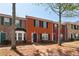 Brick townhouses with a mix of shutter colors, including black, red, and green, under a clear blue sky at 7712 Autry Circle # 204, Douglasville, GA 30134