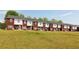 Exterior view of red brick and white siding townhomes with a large backyard at 7712 Autry Circle # 204, Douglasville, GA 30134