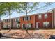 Townhouse exteriors with brick facades, green and black shutters, and landscaped front yards on a sunny day at 7712 Autry Circle # 204, Douglasville, GA 30134