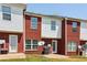 Back exterior view showcasing red brick and white siding townhomes and grassy area at 7712 Autry Circle # 204, Douglasville, GA 30134
