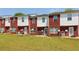 Exterior of townhomes with red brick and white siding plus a large lawn area at 7712 Autry Circle # 204, Douglasville, GA 30134