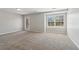 Bright living room with neutral walls, carpet flooring, and a glass panel door to the exterior at 7712 Autry Circle # 204, Douglasville, GA 30134