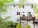 The back exterior features a charming deck, a white exterior, and an umbrella-covered patio seating area at 2262 Silver Fox Ln, Buford, GA 30519