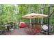 Outdoor deck with dining set and umbrella, surrounded by lush trees and greenery at 2262 Silver Fox Ln, Buford, GA 30519
