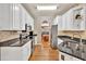 Galley kitchen featuring white cabinets, granite countertops and stainless steel appliances overlooking dining area at 2262 Silver Fox Ln, Buford, GA 30519