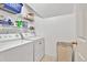 Bright laundry room featuring washer and dryer units, shelving and door at 2262 Silver Fox Ln, Buford, GA 30519
