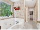 Bright bathroom featuring a soaking tub, large window, shower, and walk-in closet at 2262 Silver Fox Ln, Buford, GA 30519