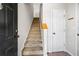 View of the carpeted staircase to the upper level next to a white door, providing access to the home's second floor at 603 Spring Heights Se Ln # 6, Smyrna, GA 30080