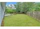 Spacious backyard featuring a manicured lawn, a fire pit, and a wood fence providing privacy at 1080 Smoke Hill Ln, Hoschton, GA 30548