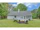 Backyard view featuring a fire pit, picnic table, and well-maintained lawn perfect for entertaining at 1080 Smoke Hill Ln, Hoschton, GA 30548