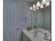 This bathroom has a white vanity, a large mirror, and stylish vanity lights at 1080 Smoke Hill Ln, Hoschton, GA 30548