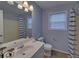 This bathroom is fully equipped with a white vanity, mirror, toilet, and shower at 1080 Smoke Hill Ln, Hoschton, GA 30548