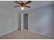 This bedroom features neutral carpet, ceiling fan, closet, and is painted with light gray walls at 1080 Smoke Hill Ln, Hoschton, GA 30548