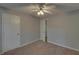 This bedroom features neutral carpet, closet, ceiling fan, and light gray walls at 1080 Smoke Hill Ln, Hoschton, GA 30548
