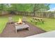 Cozy backyard fire pit seating area with a picnic table, perfect for outdoor entertaining and relaxation at 1080 Smoke Hill Ln, Hoschton, GA 30548