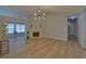 Open living room showcasing modern light fixture, fireplace, and seamless flooring at 1080 Smoke Hill Ln, Hoschton, GA 30548