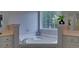 This bathroom boasts a deep soaking tub with tile surround, vanity with sink, and bright window at 1080 Smoke Hill Ln, Hoschton, GA 30548