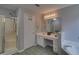 Well-lit main bathroom has a glass shower, vanity with sink, and a linen closet at 1080 Smoke Hill Ln, Hoschton, GA 30548