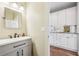 Neutral bathroom with white vanity, sleek fixtures, and an attached butler's pantry at 5605 Preserve Cir, Johns Creek, GA 30005
