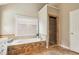 Bright bathroom features a large tub with stone accents and glass enclosed shower at 5605 Preserve Cir, Johns Creek, GA 30005