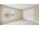 Neutral bedroom features carpet, a ceiling fan, window, and double door closet at 5605 Preserve Cir, Johns Creek, GA 30005
